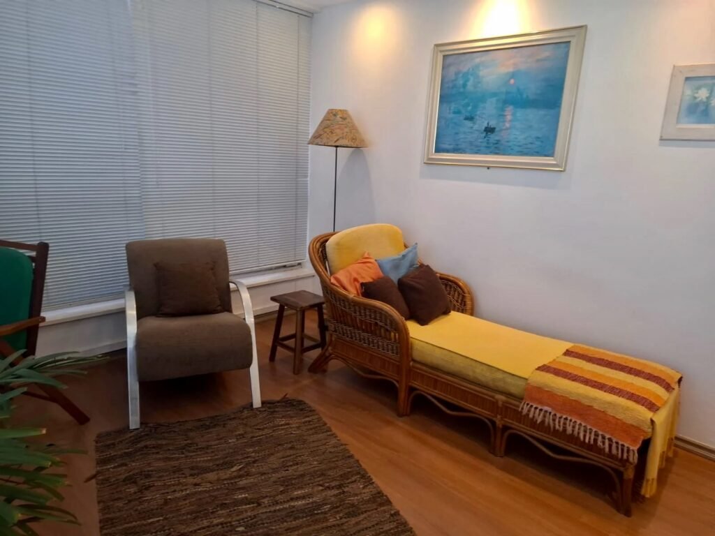 Consultório na Avenida Paulista com poltronas e divã